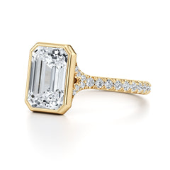 Emerald cut moissanite engagement ring with gold band and pavé side stones