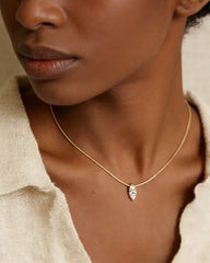 Woman wearing a gold chain with a marquise-cut moissanite pendant necklace