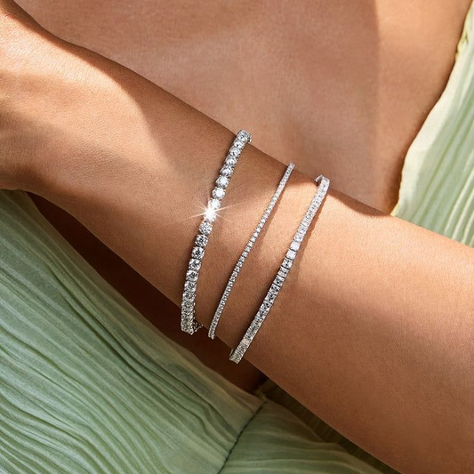 Woman wearing three sparkling moissanite tennis bracelets on her wrist in natural light