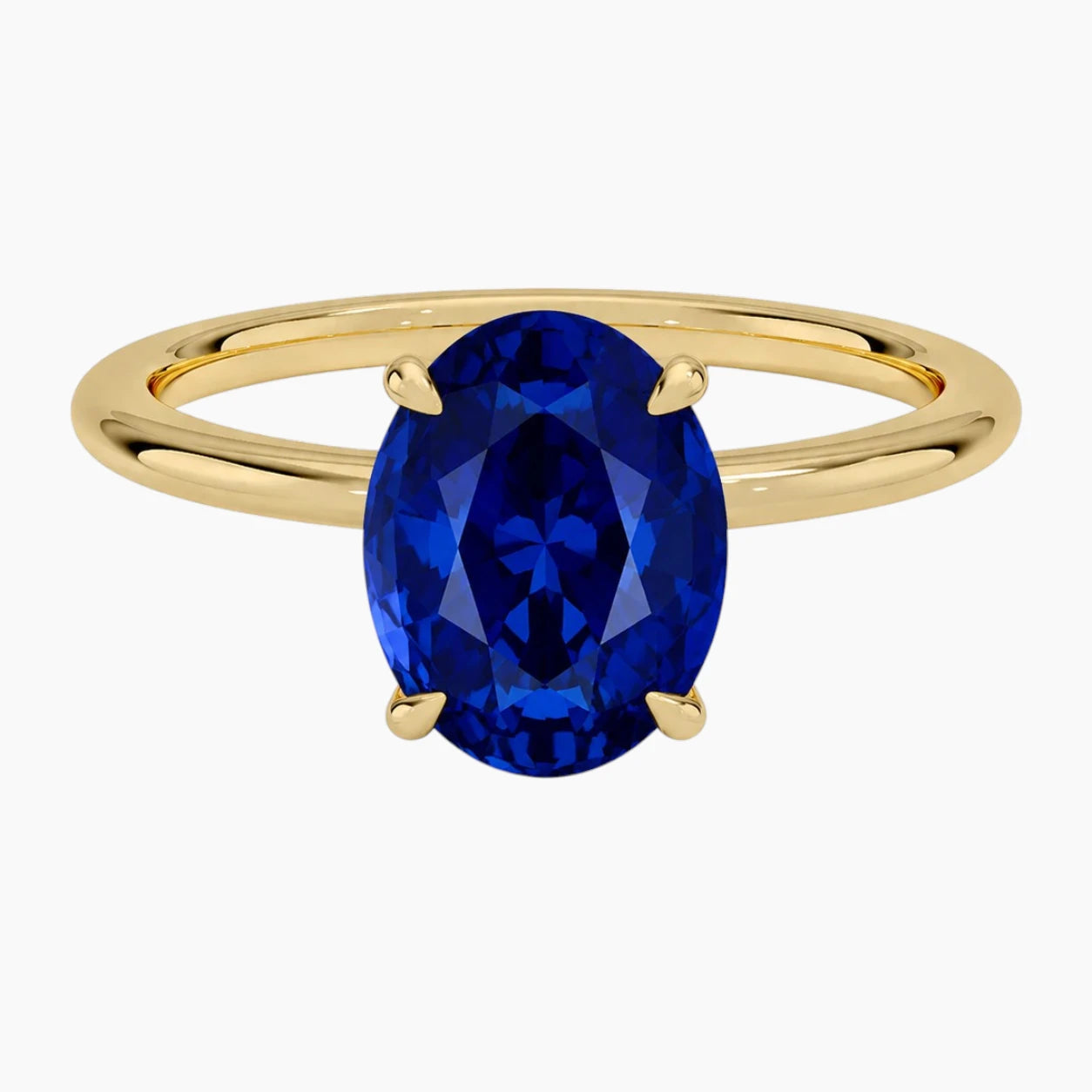 Overhead view of a vibrant 2-carat oval lab-grown blue sapphire ring with a smooth 18K yellow gold-plated band by Stdiam