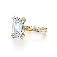 Emerald cut moissanite engagement ring with twisted gold band and small accent stones