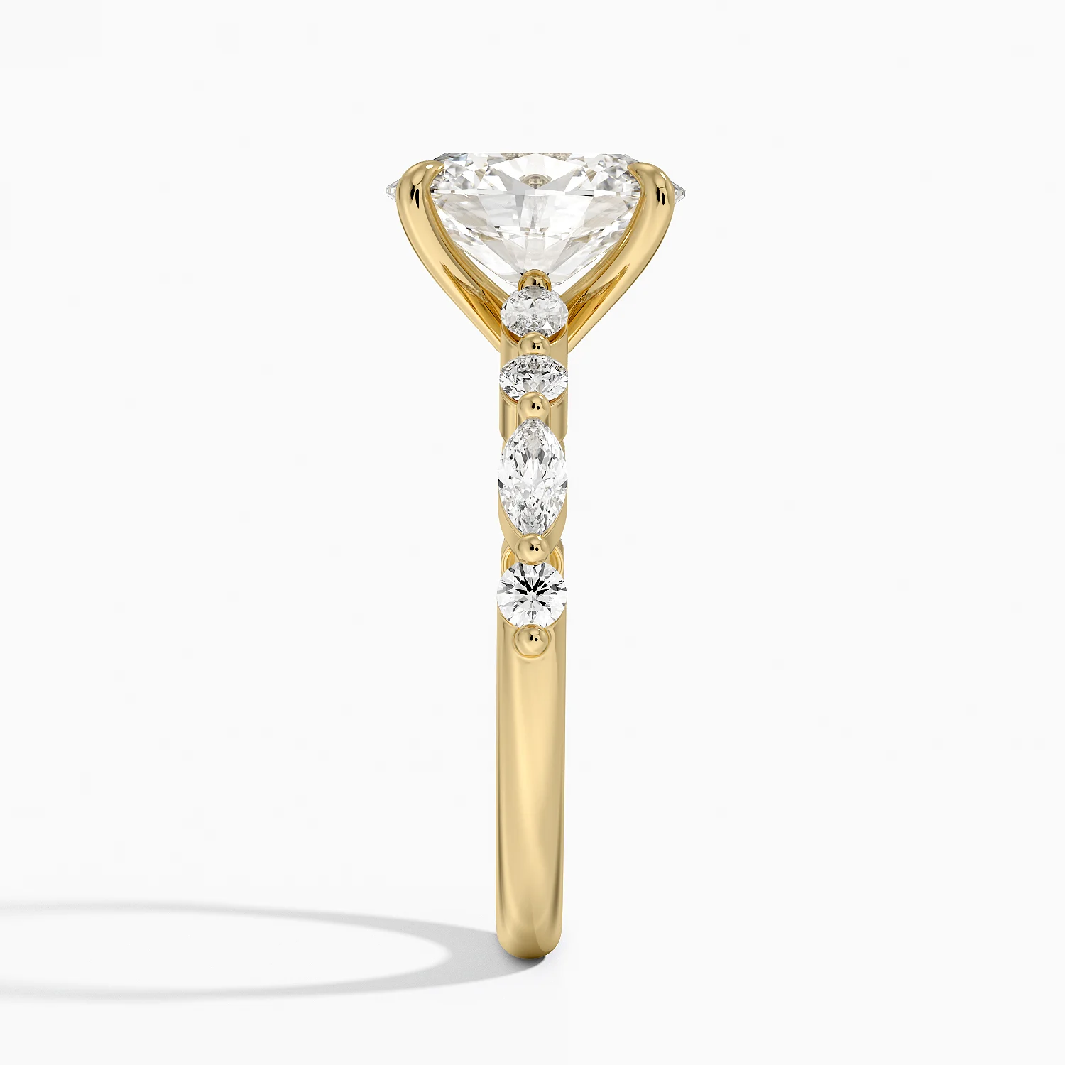 Yellow gold ring with round and marquise moissanite stones in prong setting, side view