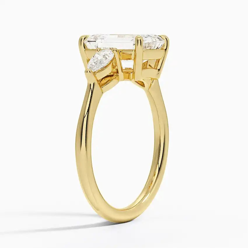 Gold moissanite engagement ring with emerald-cut center stone and marquise side stones