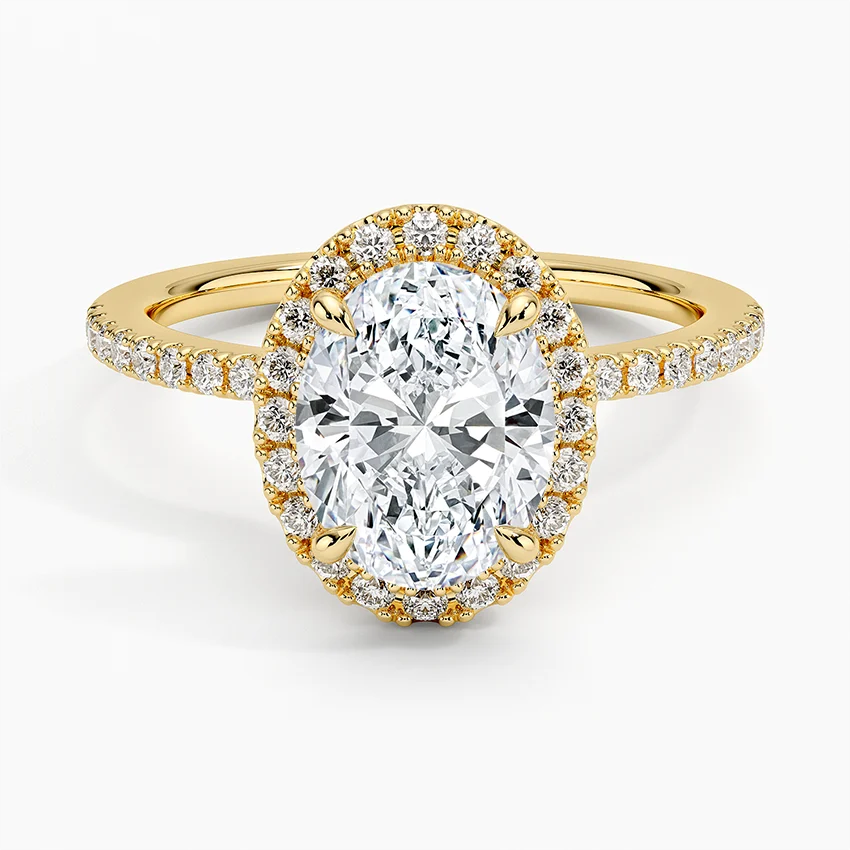 Oval cut moissanite halo engagement ring with gold band and pavé side stones