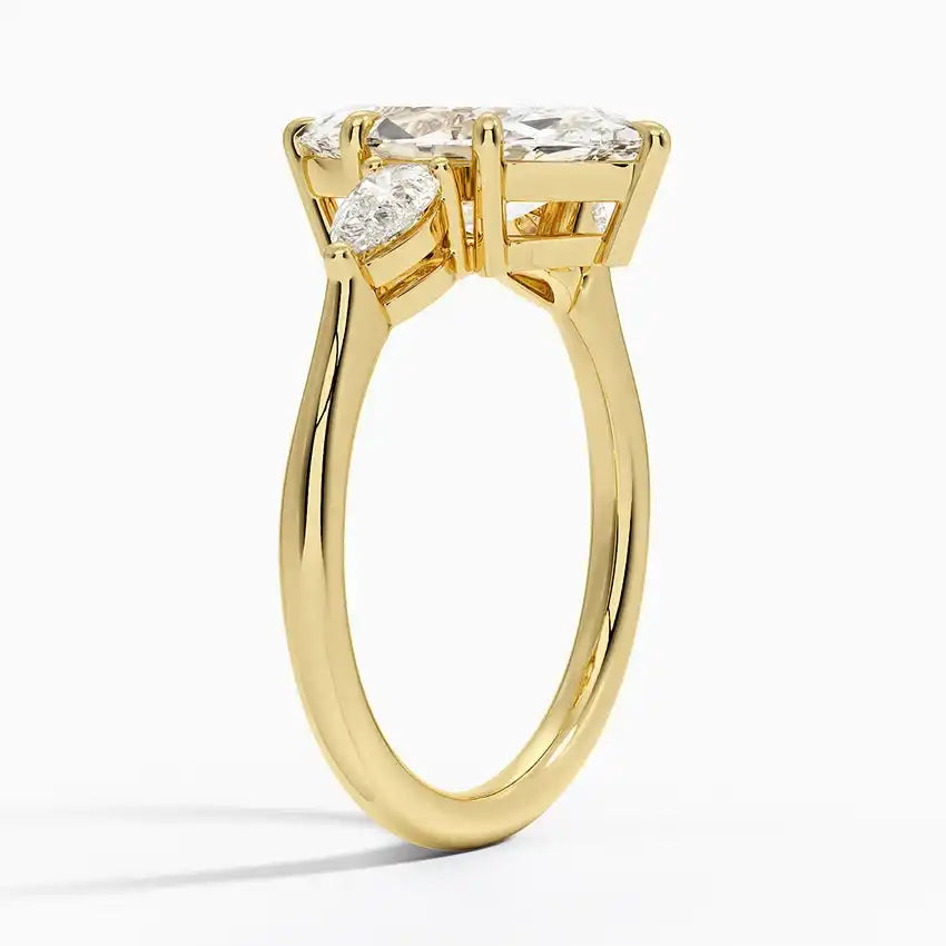 Gold moissanite engagement ring with three stones, side view showcasing elegant setting