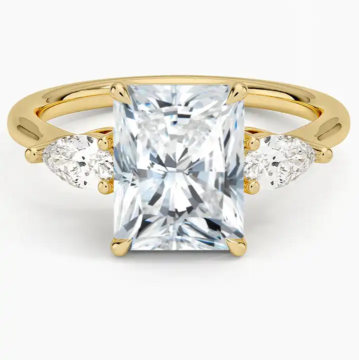Radiant cut moissanite engagement ring with pear side stones on yellow gold band