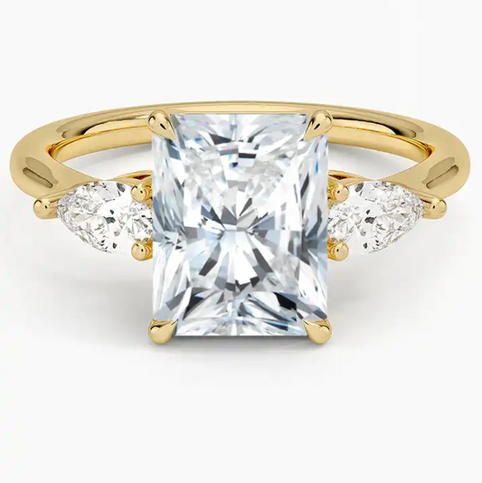 Radiant cut moissanite engagement ring with pear side stones on yellow gold band