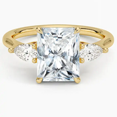 Radiant cut moissanite engagement ring with pear side stones on yellow gold band