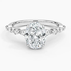 Oval moissanite engagement ring with diamond accents on a polished silver band