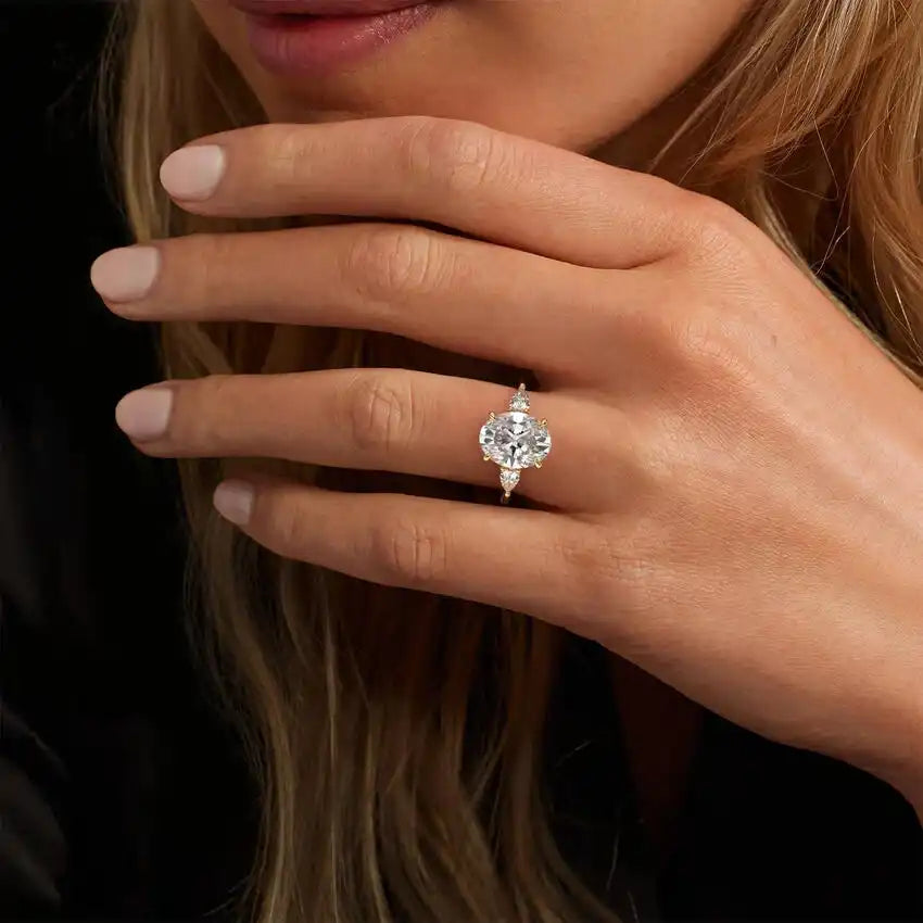 Woman wearing elegant moissanite engagement ring with round center stone and side accents