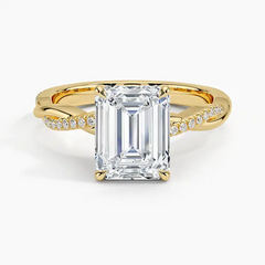 Emerald cut moissanite engagement ring with twisted gold band and pavé side stones