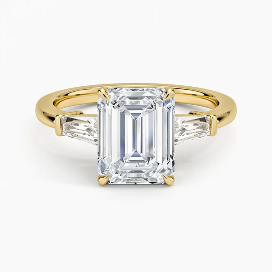 Emerald cut moissanite engagement ring with side stones on yellow gold band