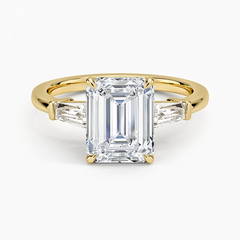 Emerald cut moissanite engagement ring with side stones on yellow gold band