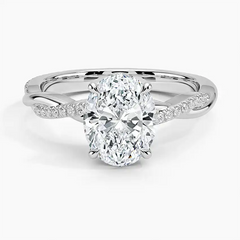 Oval cut moissanite engagement ring with twisted diamond pavé band in white metal