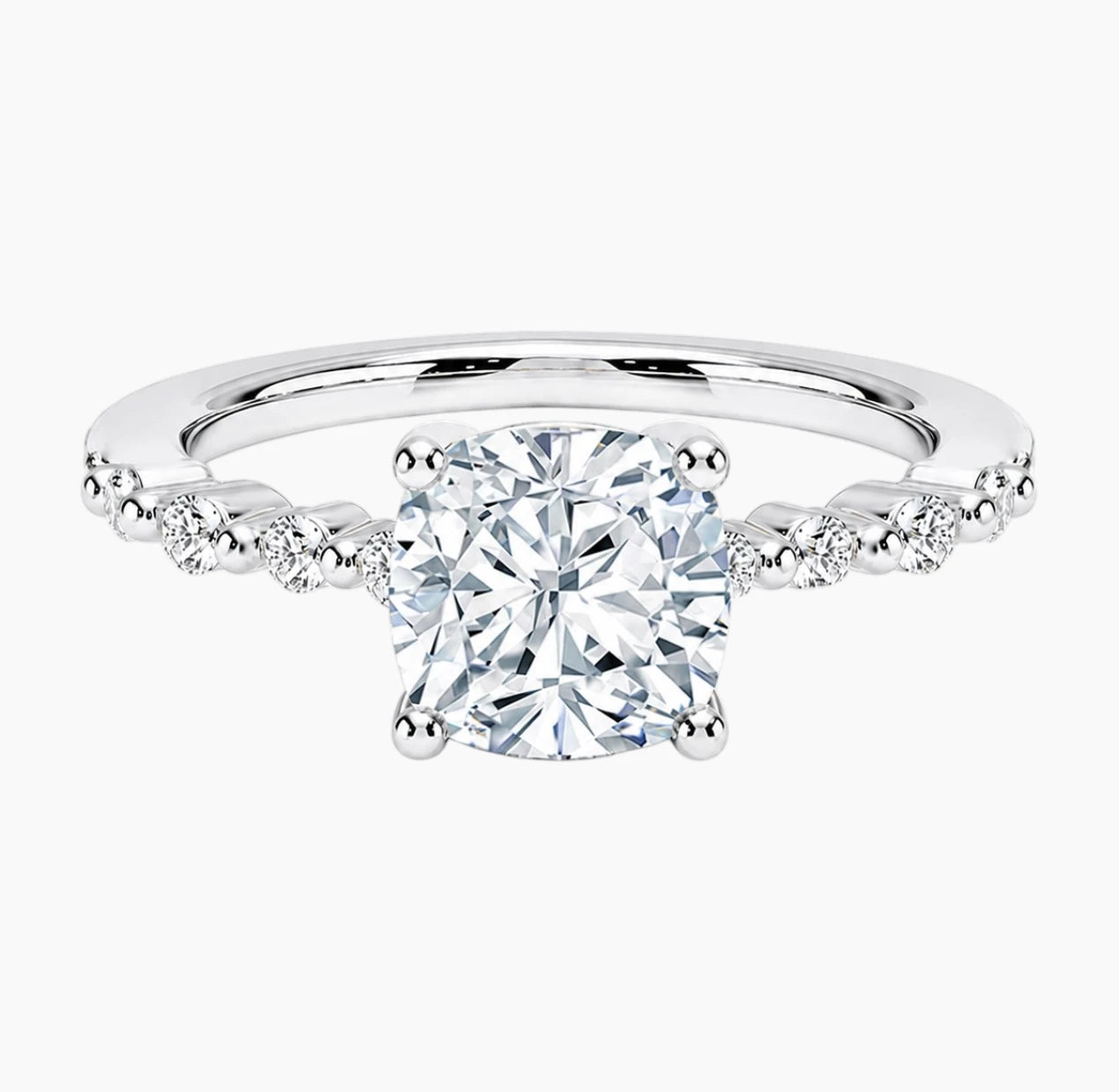 Cushion-cut moissanite ring featuring an 18K white gold-plated band set with pavé diamonds; an elegant solitaire-style engagement ring.