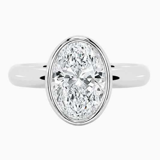 Oval bezel moissanite ring featuring a brilliant oval-cut stone and polished 2.6mm yellow gold comfort-fit band.