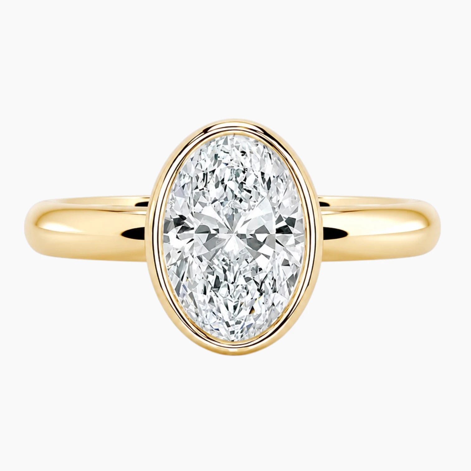 Oval bezel moissanite ring featuring a brilliant oval-cut stone and polished 2.6mm yellow gold comfort-fit band.