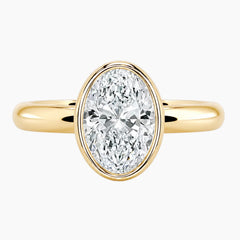 Oval bezel moissanite ring featuring a brilliant oval-cut stone and polished 2.6mm yellow gold comfort-fit band.