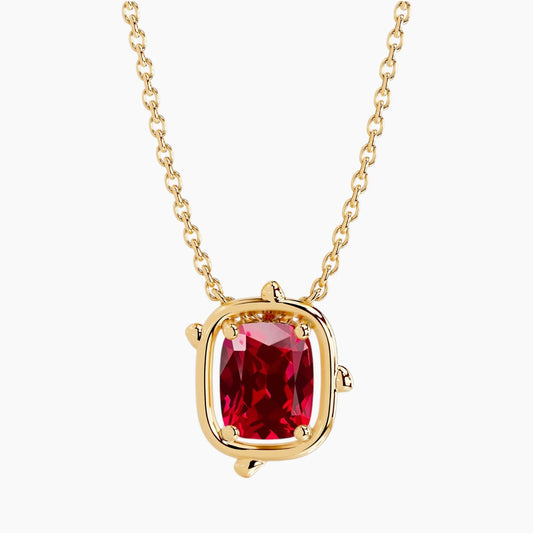 6×8mm cushion-cut ruby pendant necklace in 14K yellow gold with a minimalist bezel-inspired setting and delicate cable chain on a white background.