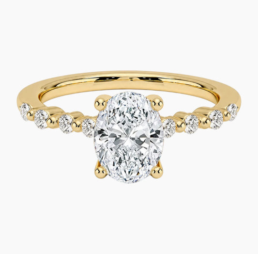 Oval-cut moissanite ring featuring an 18K white gold-plated band set with pavé diamonds; an elegant solitaire-style engagement ring.