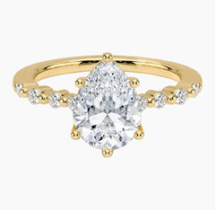 Pear-cut moissanite ring featuring an 18K white gold-plated band set with pavé diamonds; an elegant solitaire-style engagement ring.