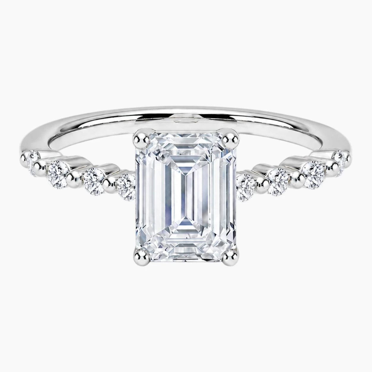 Emerald-cut moissanite ring featuring an 18K white gold-plated band set with pavé diamonds; an elegant solitaire-style engagement ring.
