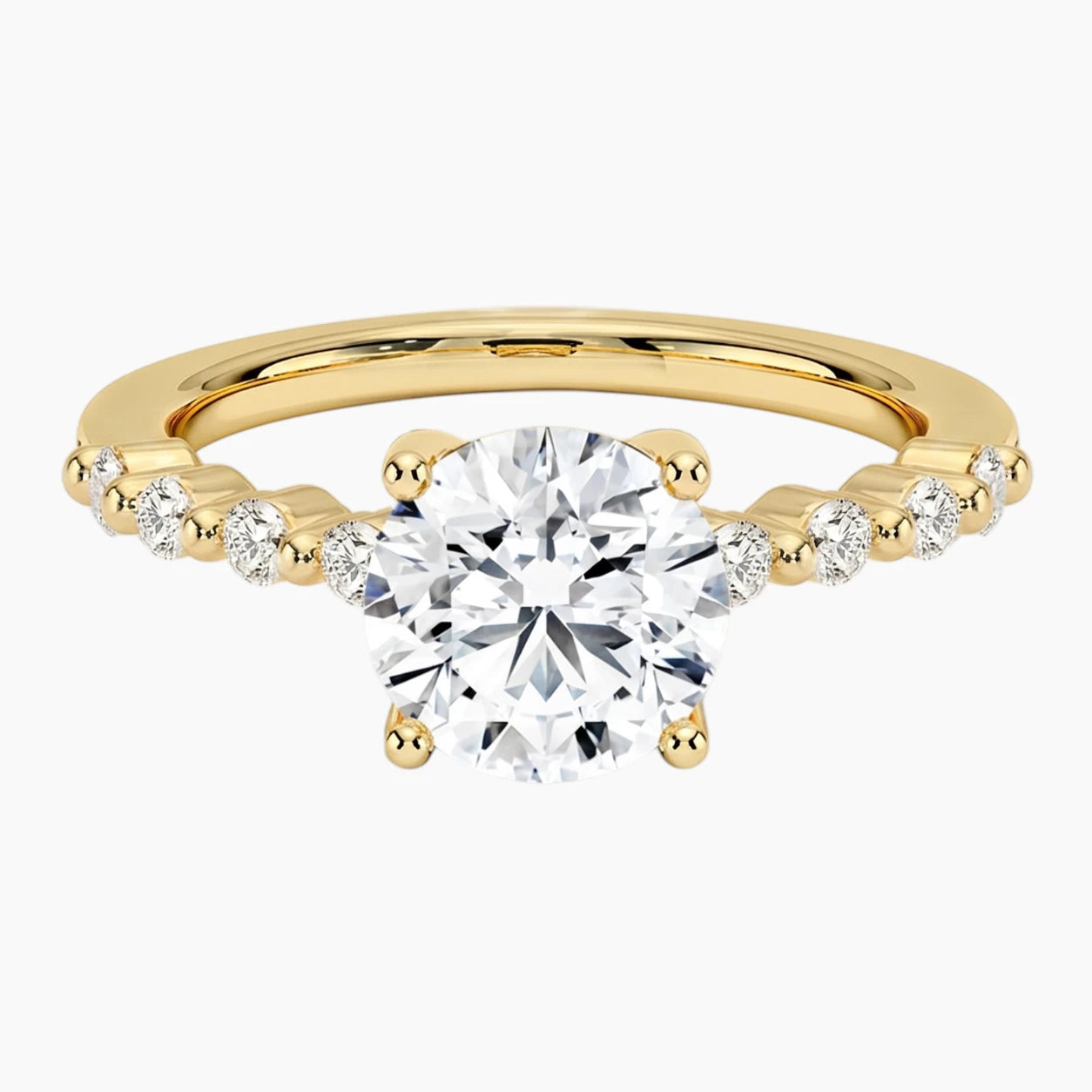 Round-cut moissanite ring featuring an 18K white gold-plated band set with pavé diamonds; an elegant solitaire-style engagement ring.
