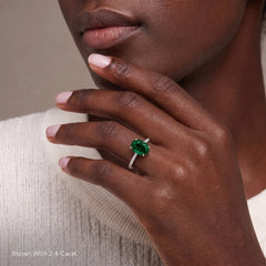 Woman wearing a 2.4 carat oval green gemstone ring with a white gold pavé band
