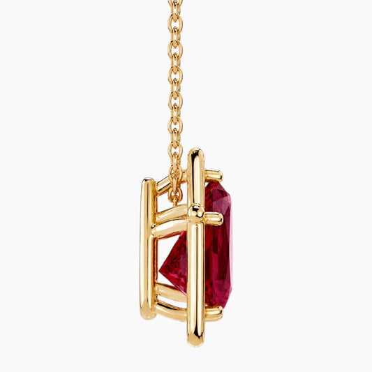 Side profile of a 6×8mm ruby pendant necklace showing the open gallery setting in polished 14K yellow gold.