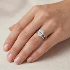 Oval moissanite engagement ring with split shank on hand, silver band jewelry