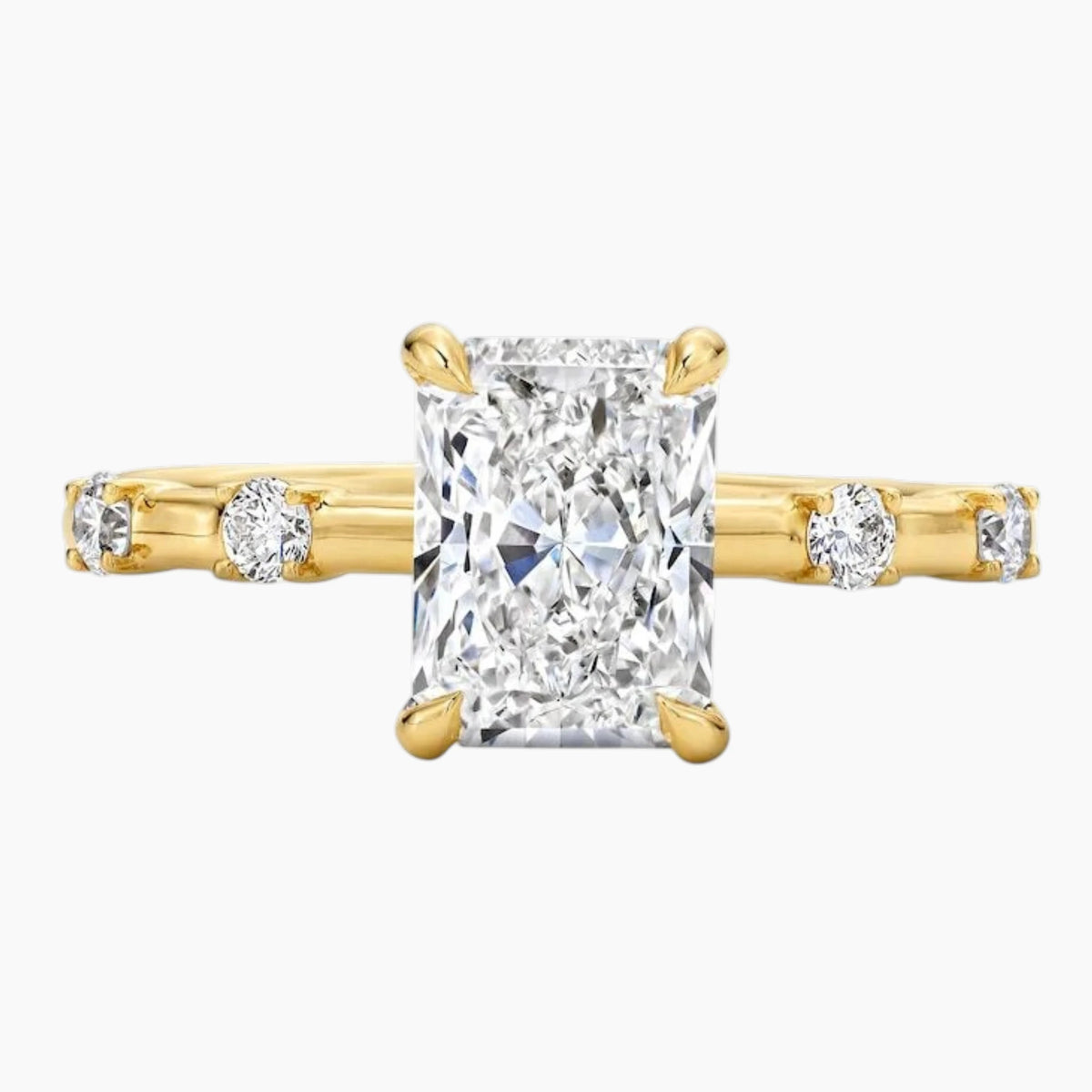 Radiant cut moissanite gold ring with side accent stones on white background