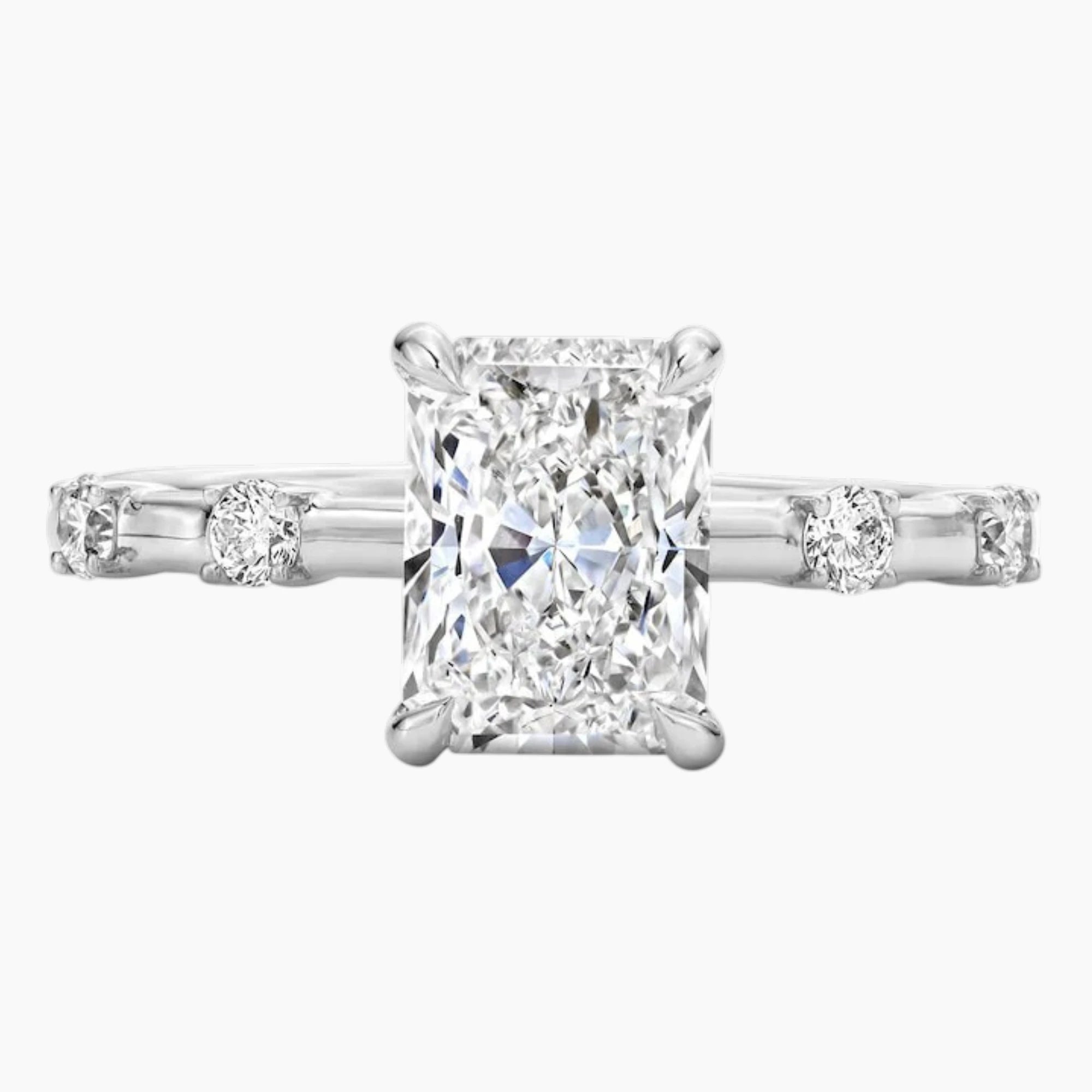 Radiant cut moissanite solitaire ring with side stones set in a white gold band