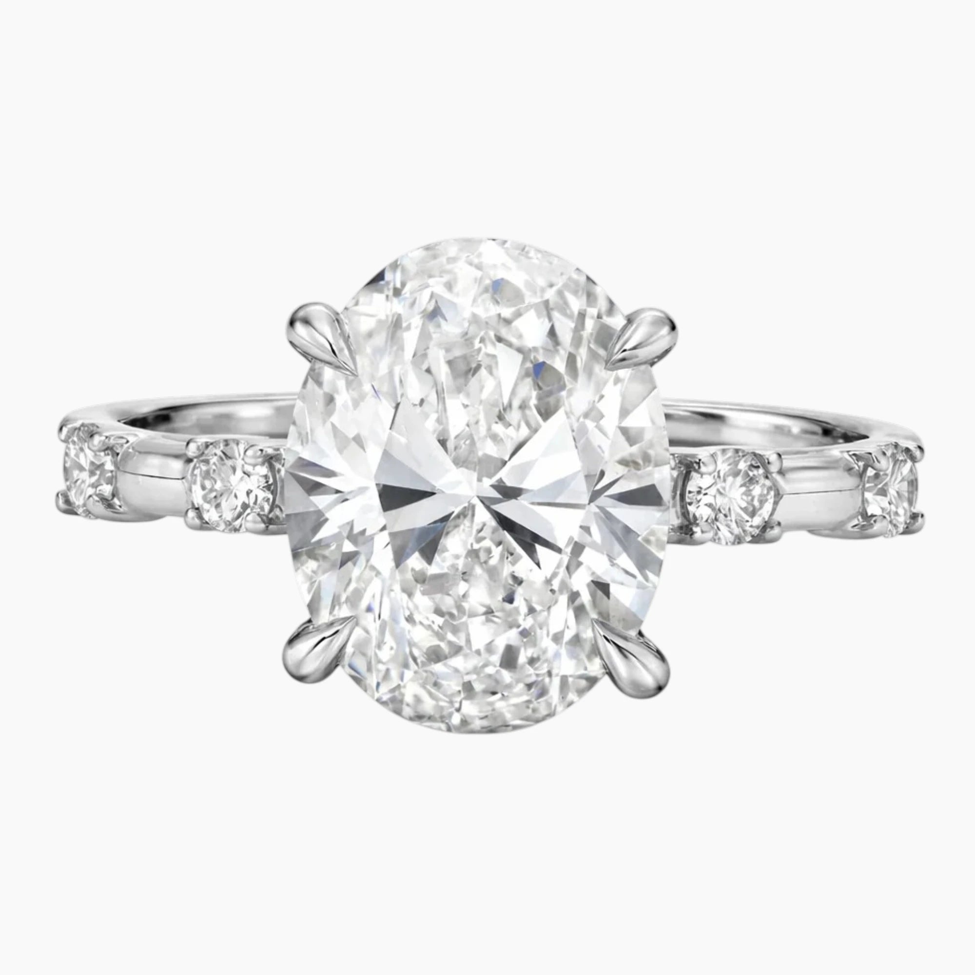 Oval moissanite engagement ring with side stones on a silver band, luxury jewelry