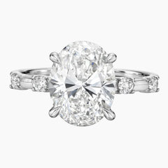 Oval moissanite engagement ring with side stones on a silver band, luxury jewelry