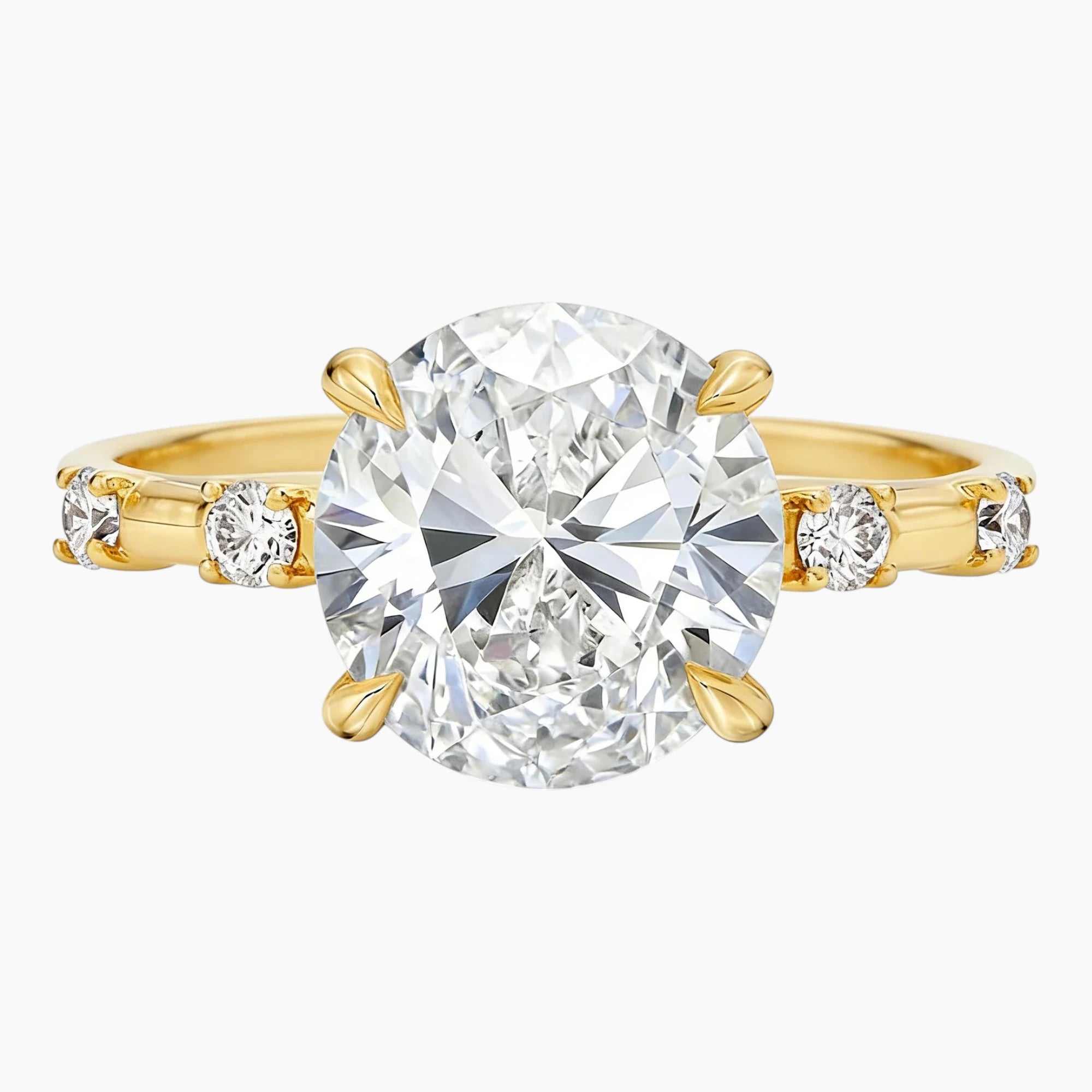 Oval moissanite engagement ring with gold band and side stones on white background