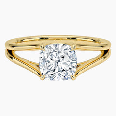 Gold split shank ring with round brilliant moissanite center stone on white background