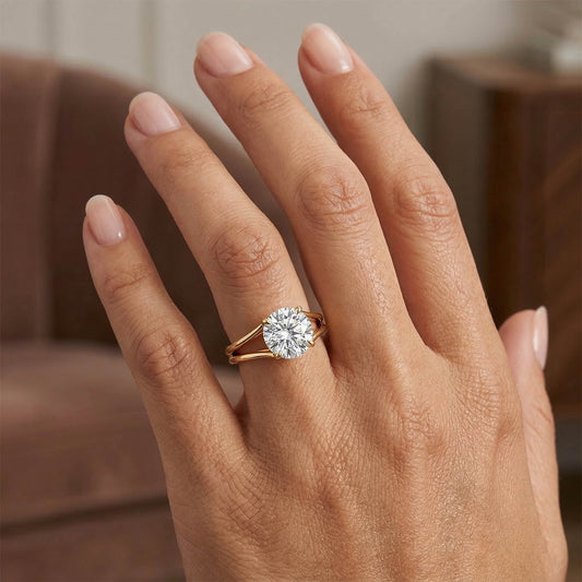 Hand wearing a gold moissanite solitaire ring with round brilliant stone
