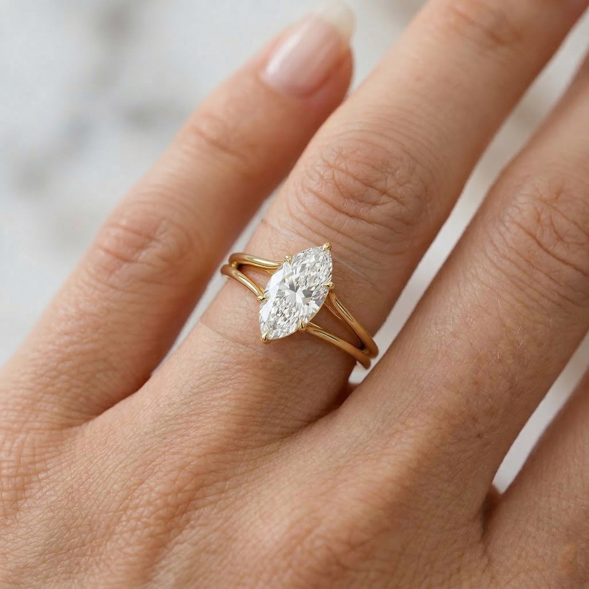Marquise cut moissanite engagement ring with gold band on hand