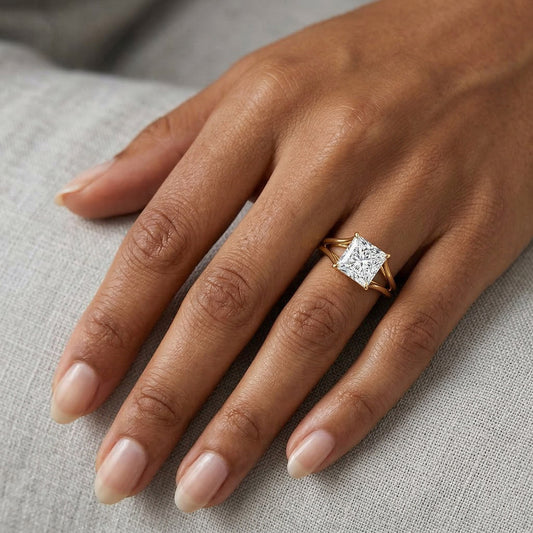 Princess cut moissanite engagement ring with gold band on hand