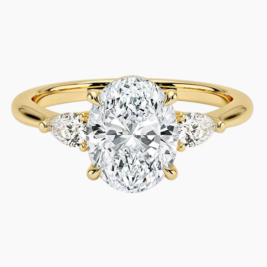 Oval moissanite engagement ring with side stones on yellow gold band
