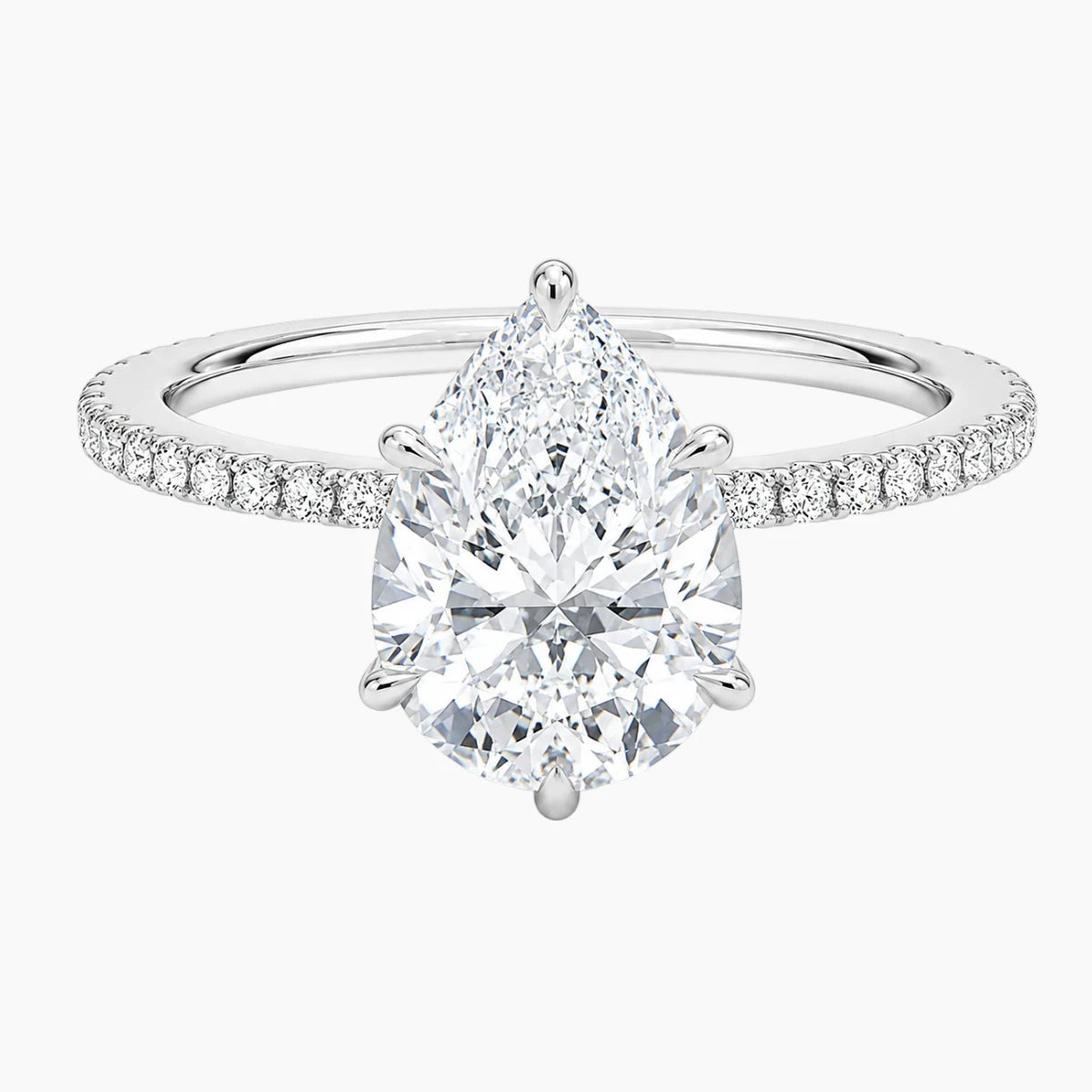 Pear-shaped moissanite engagement ring with pavé band in white gold setting