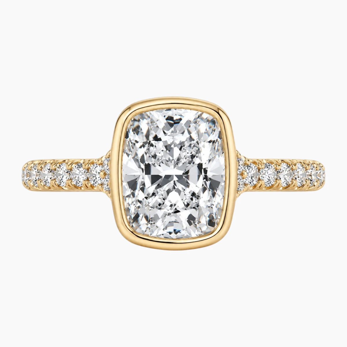 Cushion cut moissanite gold ring with pavé band on white background
