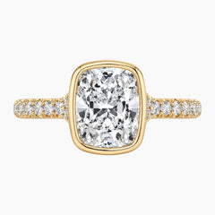 Cushion cut moissanite gold ring with pavé band on white background