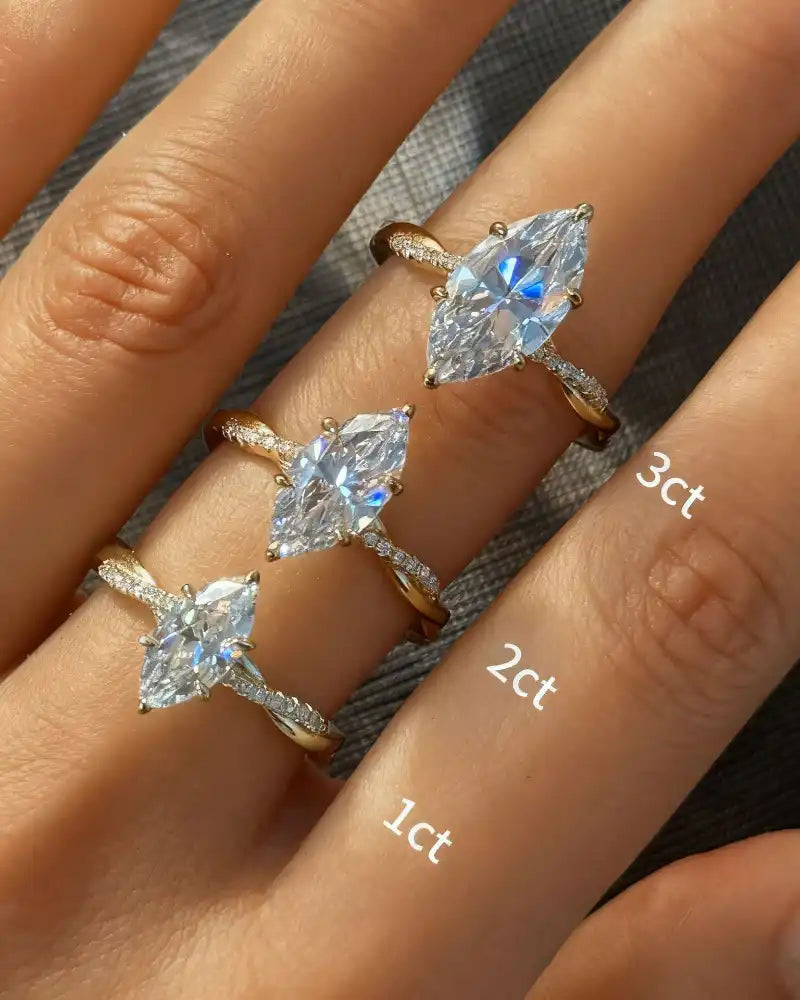 Three marquise cut moissanite rings in gold with different carat sizes on fingers