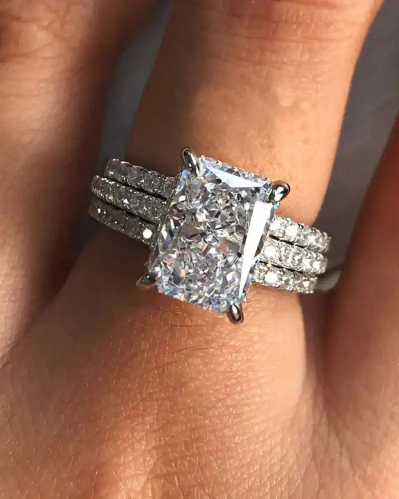 Radiant cut moissanite engagement ring with pavé band set on a woman's hand