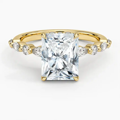 Radiant cut moissanite engagement ring with gold band and side accent stones