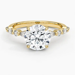 Round moissanite engagement ring with side stones on yellow gold band