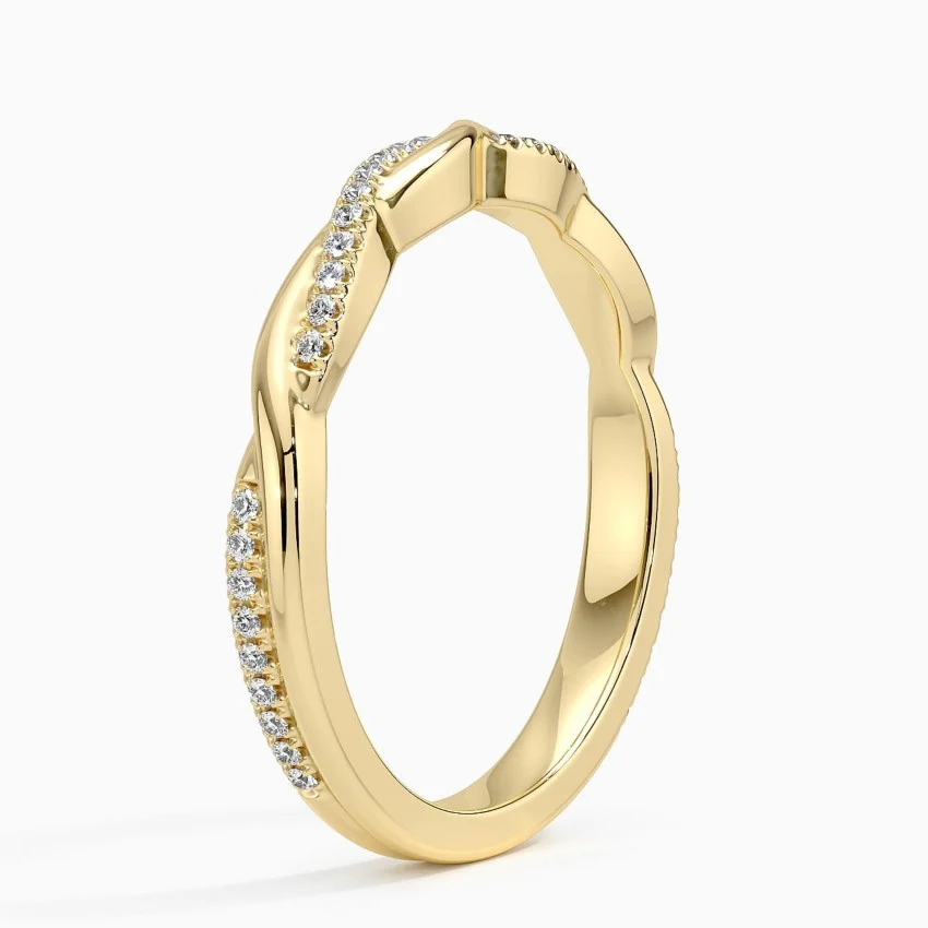 Gold band ring with pavé moissanite stones in a twisted design on white background