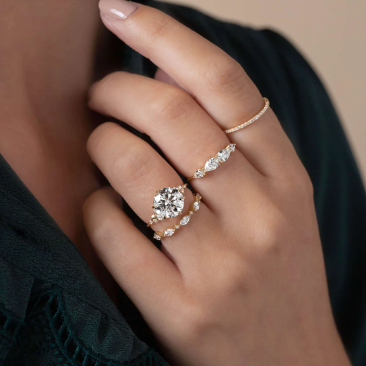 Hand wearing elegant gold moissanite rings with brilliant gemstones, close-up
