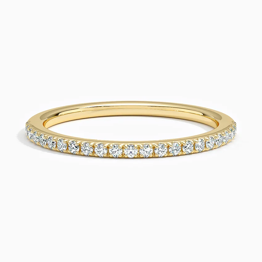 Gold moissanite eternity band with round gemstones in a pavé setting on white background